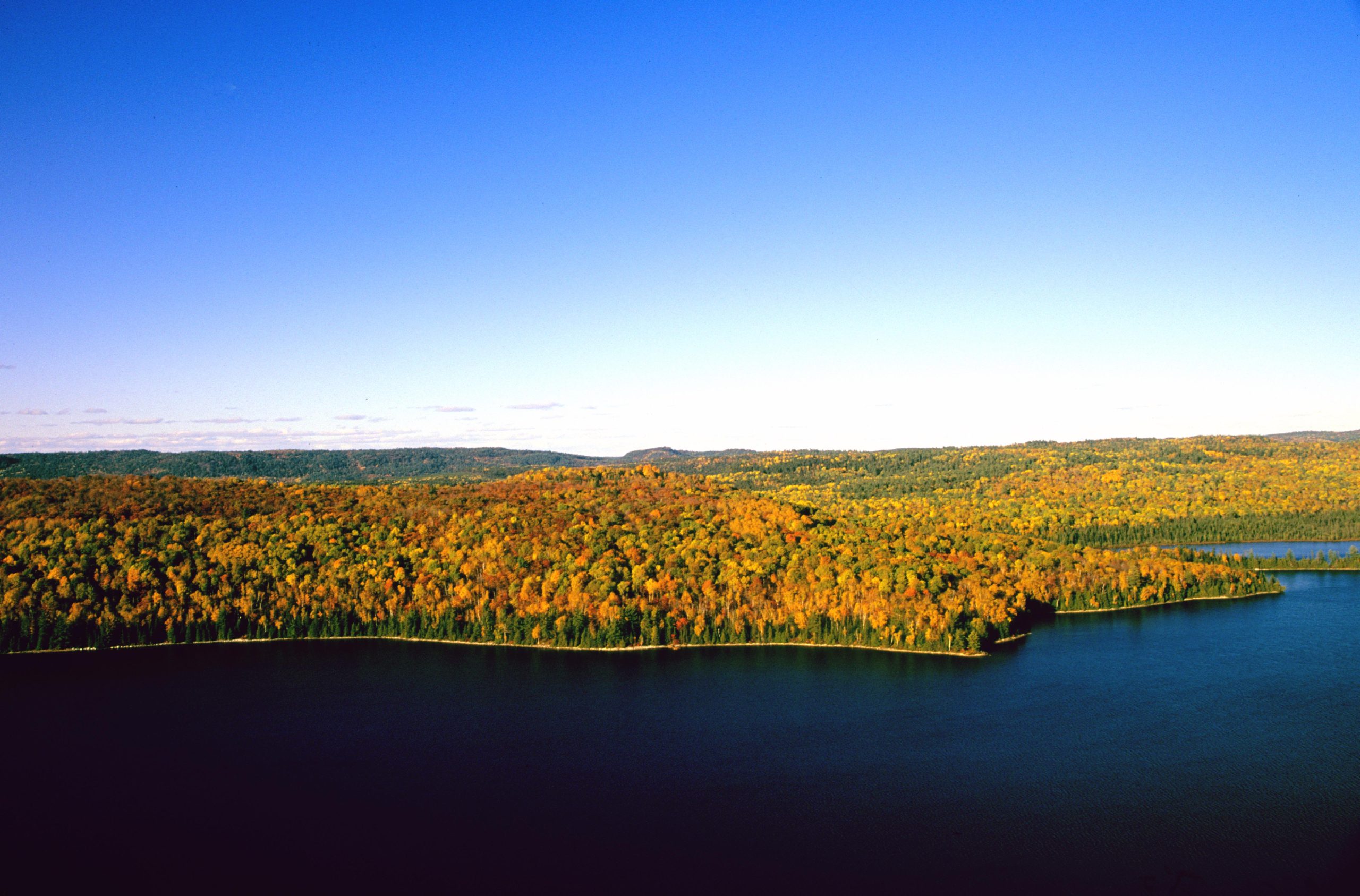 View of a lake and forest with fall colours from a hiking lookout at Mississagi Provincial Park