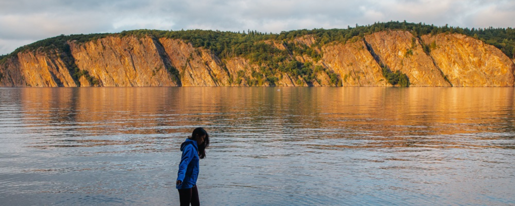 A person on the shore of a lake at Bon Echo