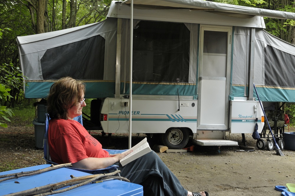 person sitting in front of tent trailer