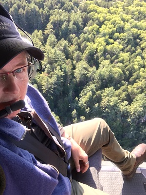 staff looking over forest in helicopter