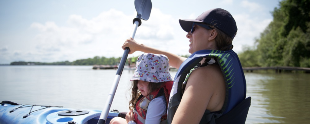 A parent and a child kayaking together on the water