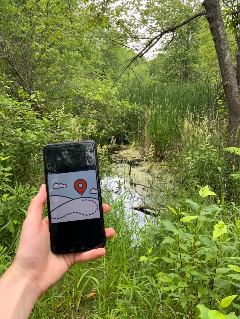 person with phone on trail