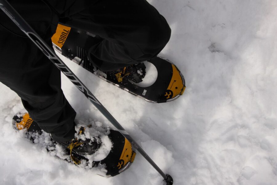 Snowshoes, boots and poles in snow