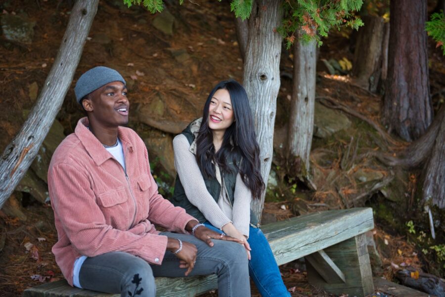 Two adults sitting on bench in forest