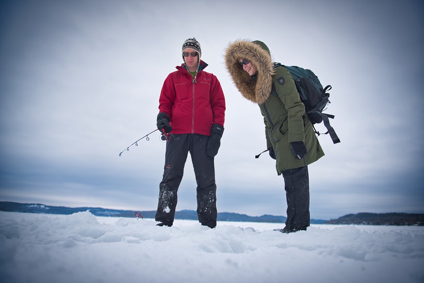 two visitors ice fishing on lake