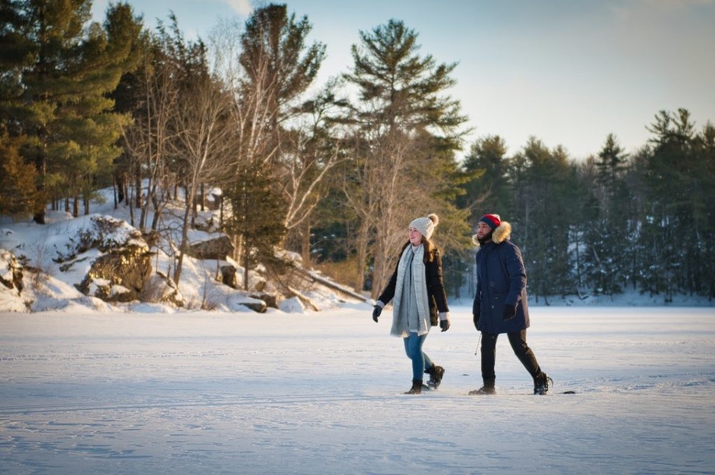 Two people walking across a frozen snowy lake