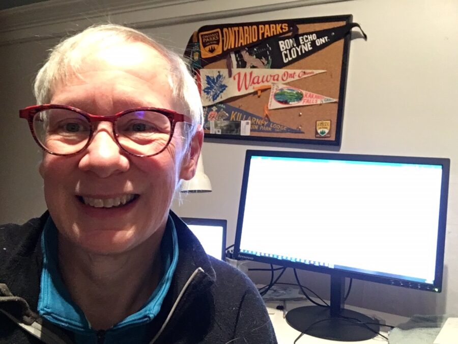 woman with computer screen and Ontario Parks bulletin board