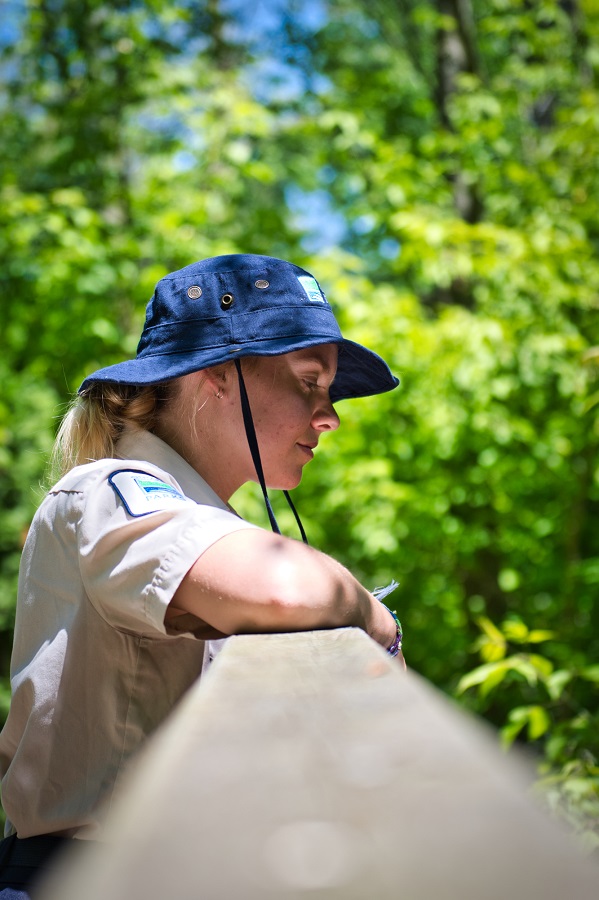 A woman looking over a railing on a bridge.