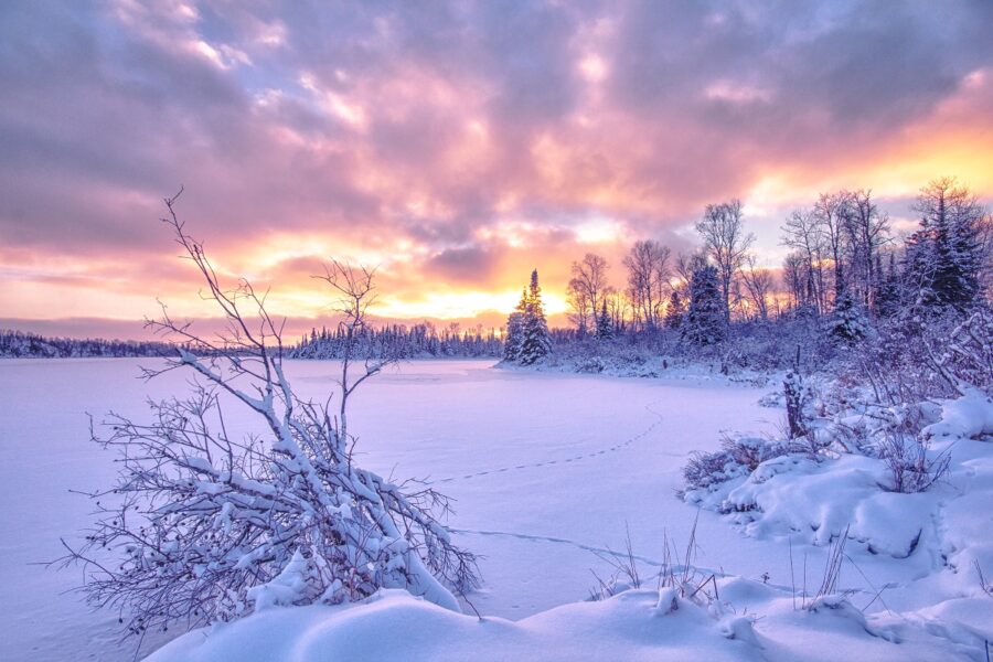 A snowy landscape over a frozen lake.