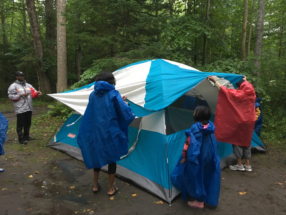 Group sets up tent in the rain. 