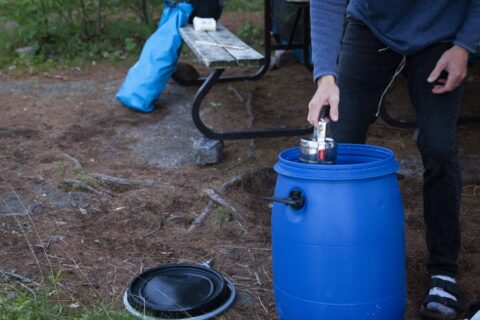 Packing food into a bear barrel in the backcountry.