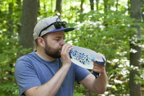 Man drinking filtered water while camping.