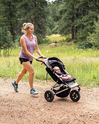 Woman jogging while pushing stroller. 