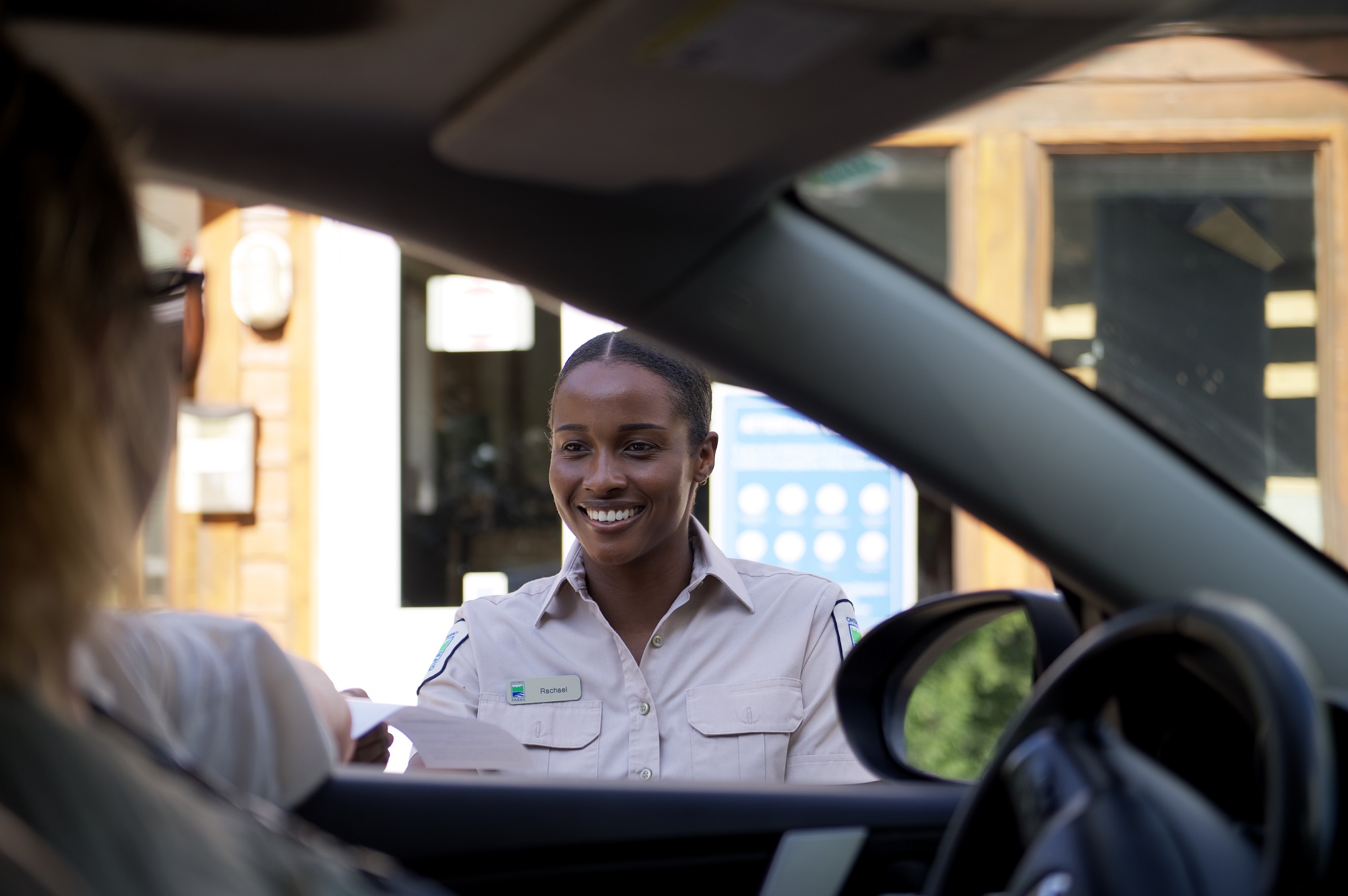 staff greeting visitor in vehicle