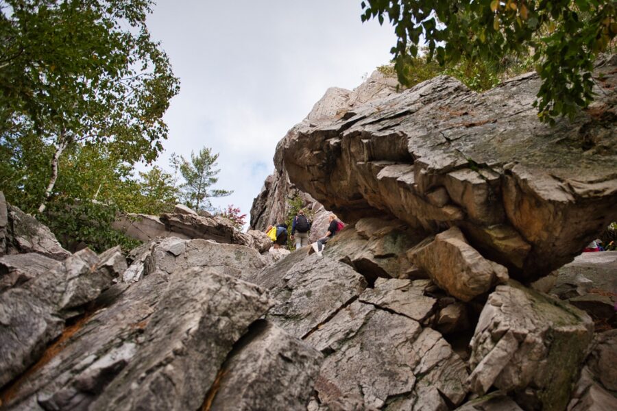 a group of hikers traversing large boulders