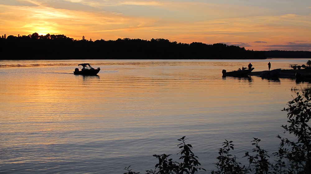 boat on lake with sun setting