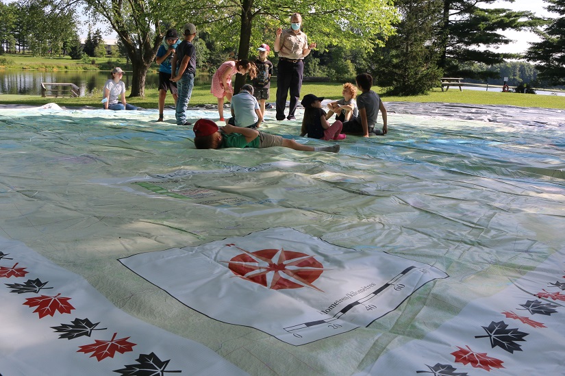 Staff teaching on map to group of students.