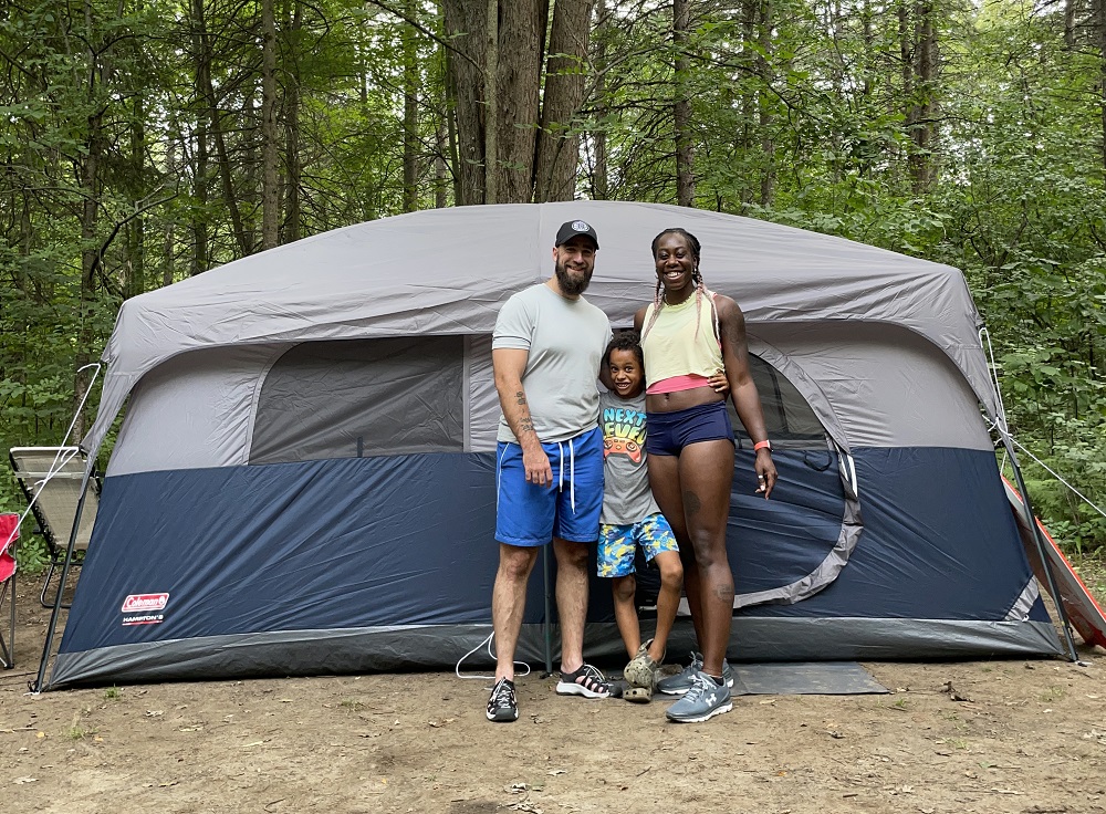 family standing in front of tent on campsite