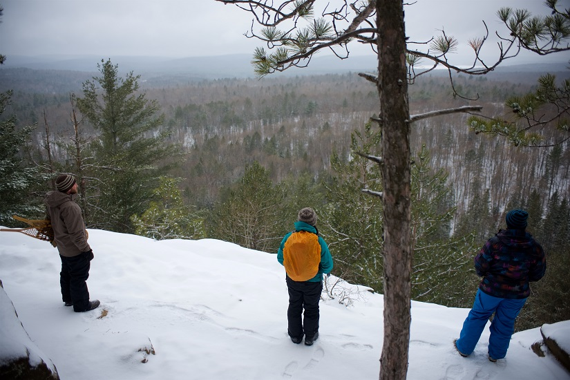 un groupe de trois personnes debout devant un belvédère en hiver