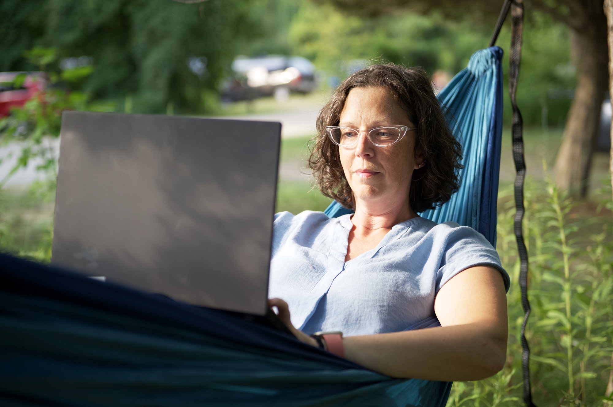 person in hammock using laptop