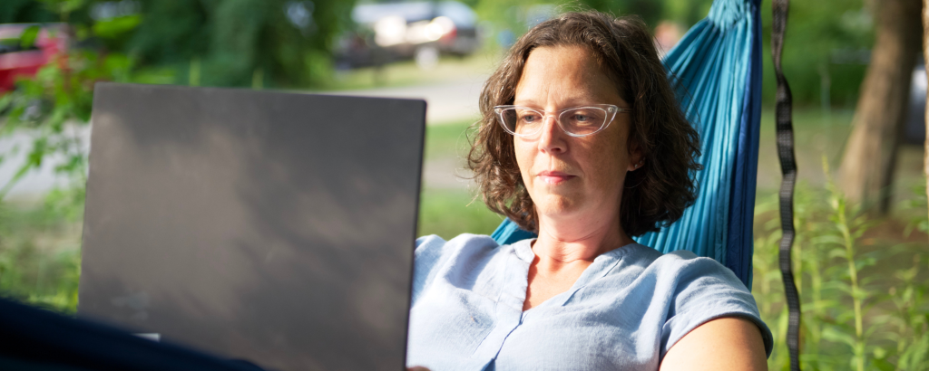 person in hammock using laptop