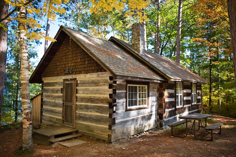 Wooden cabin in forest.