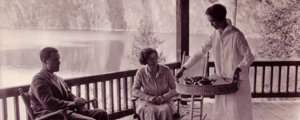 Black and white photo of guests seated on the porch of the inn