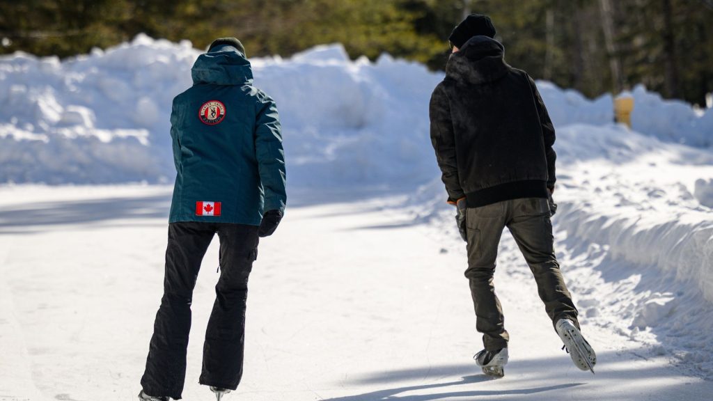 the backs of two skaters on ice trail
