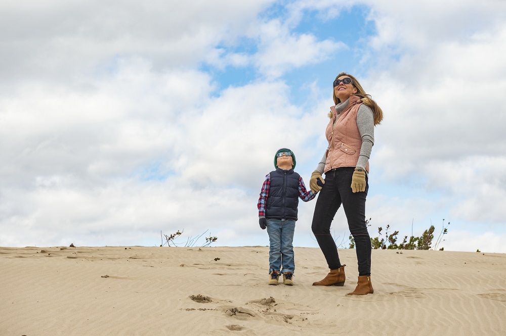 mother and child standing on beach