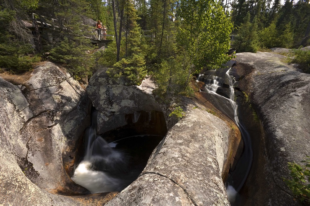 hiker on boardwalk looking at potholes