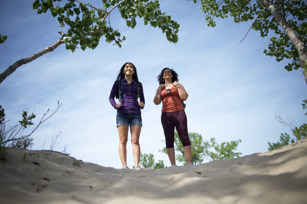 two people standing on sand