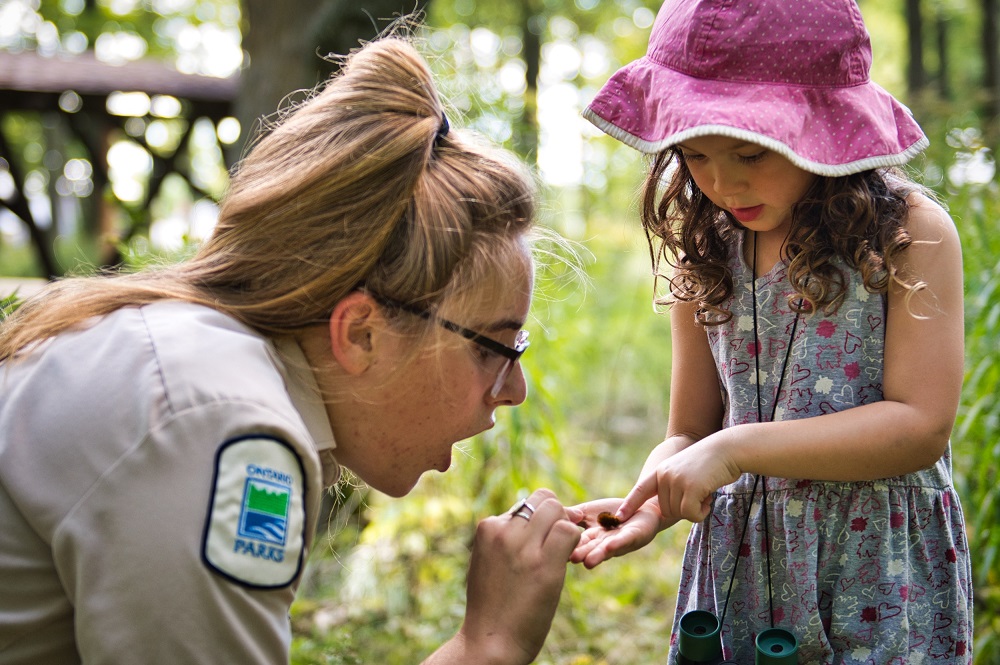 staff looking at bug with child