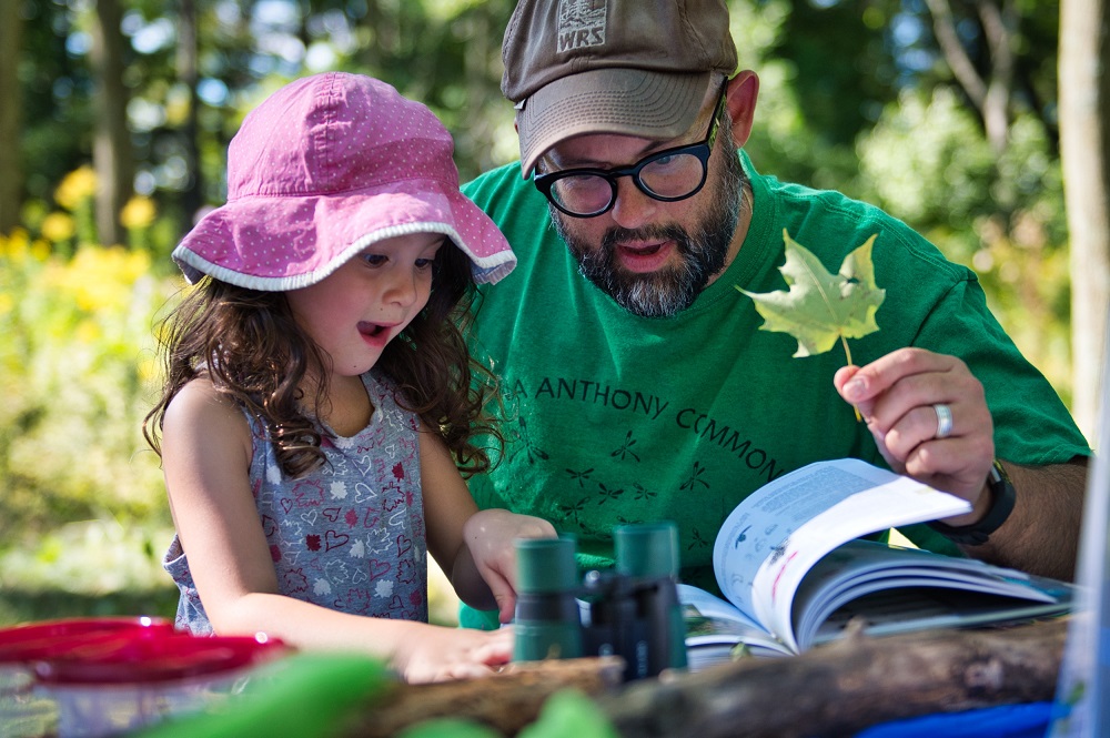 father and child looking at activity book