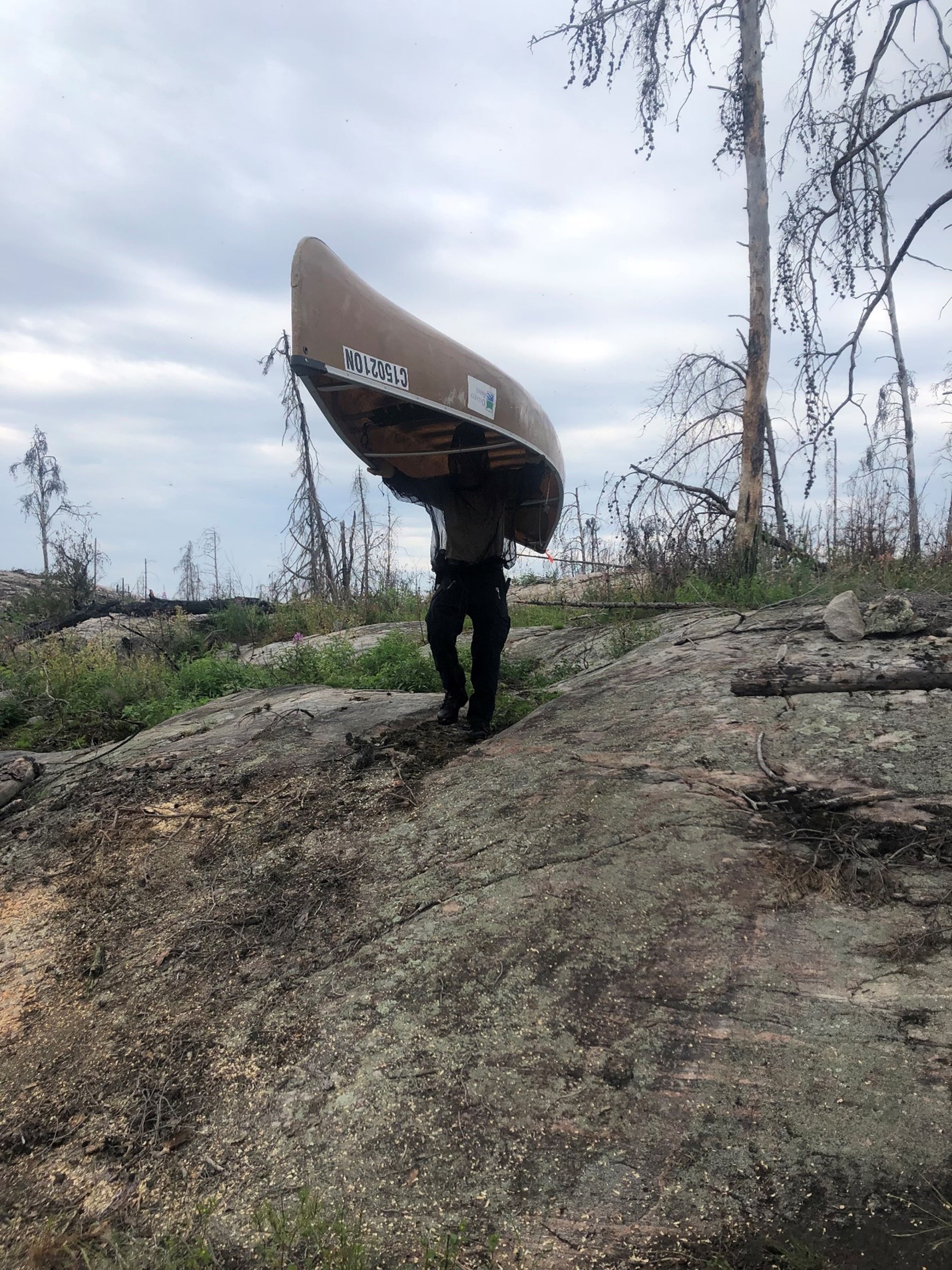 person portaging canoe