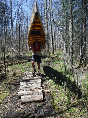 person portaging canoe