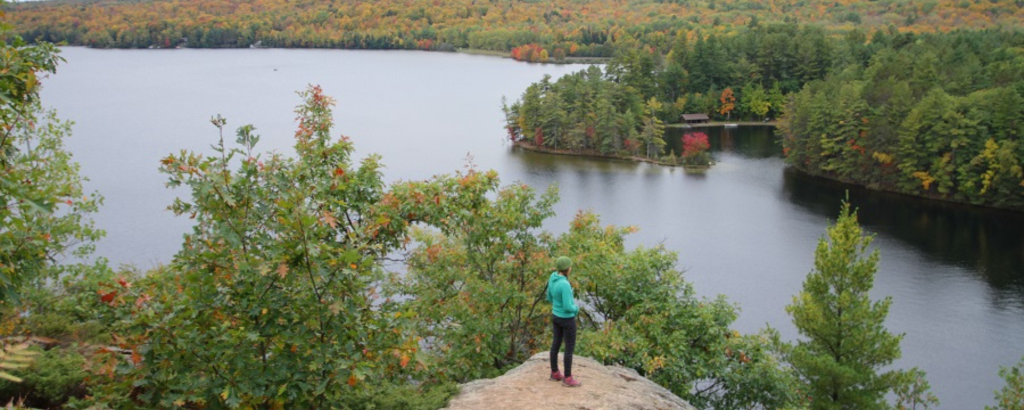A hiker on a rocky lookout over a lake