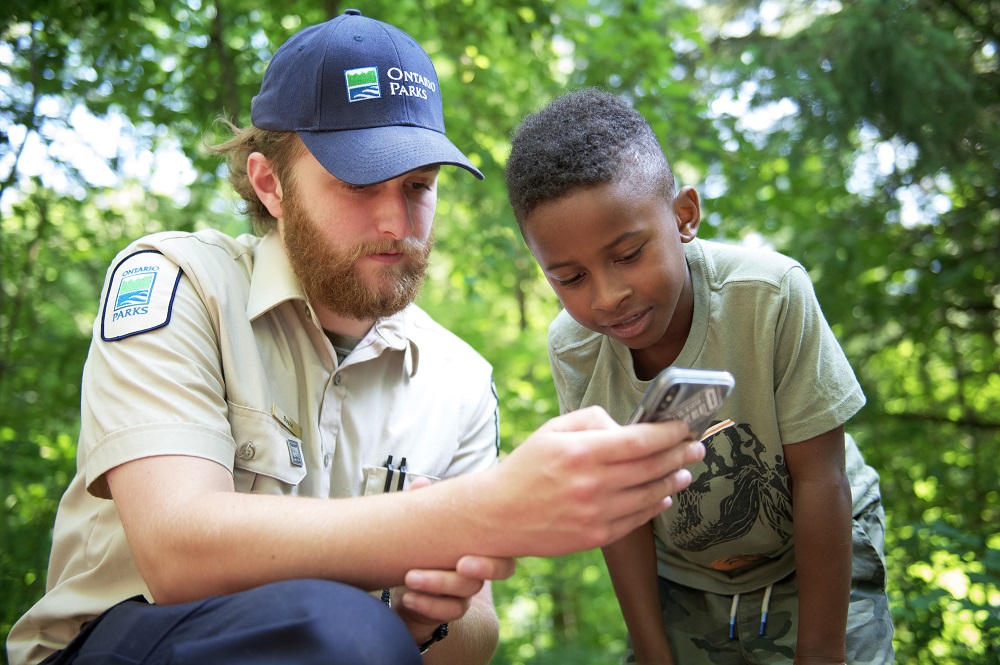 staff looking at phone with visitor