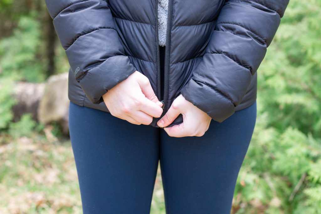 person zipping up jacket