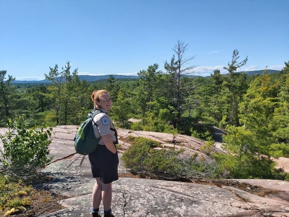 staff standing on rocky lookout