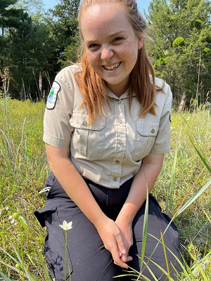 staff kneeling in meadow