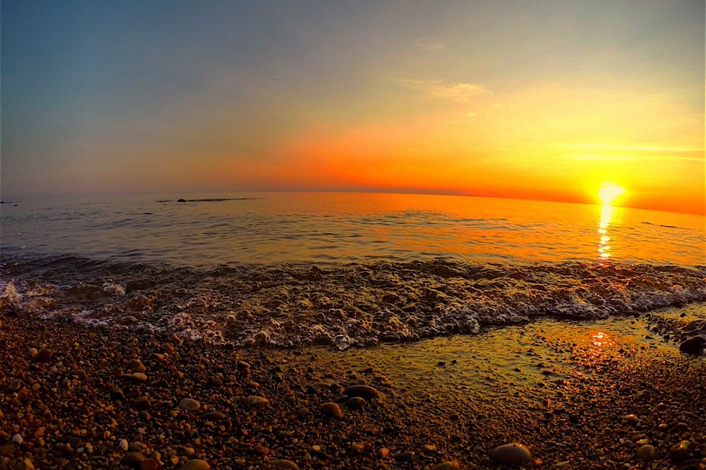 waves crashing on shore at sunset