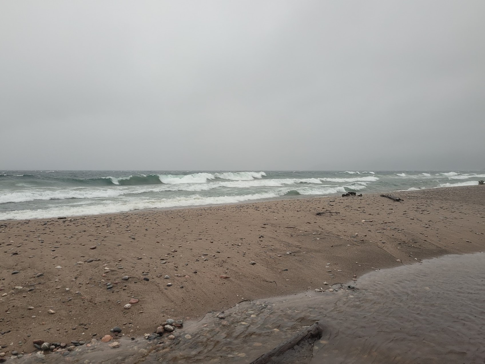 waves crashing into beach on stormy day