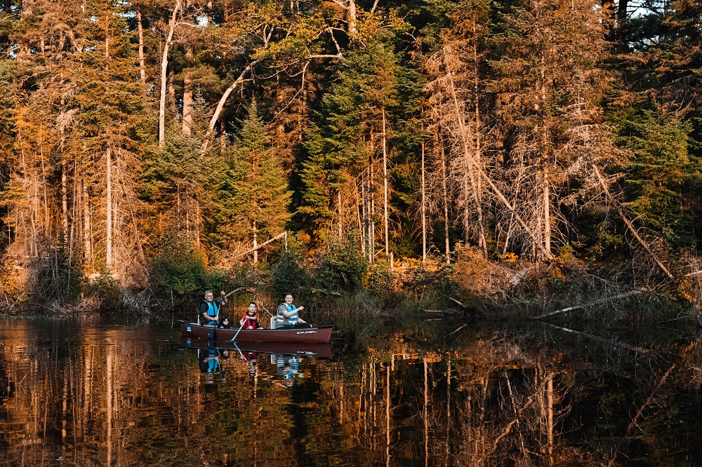 Family paddling the Bonnechere River during fall colours,