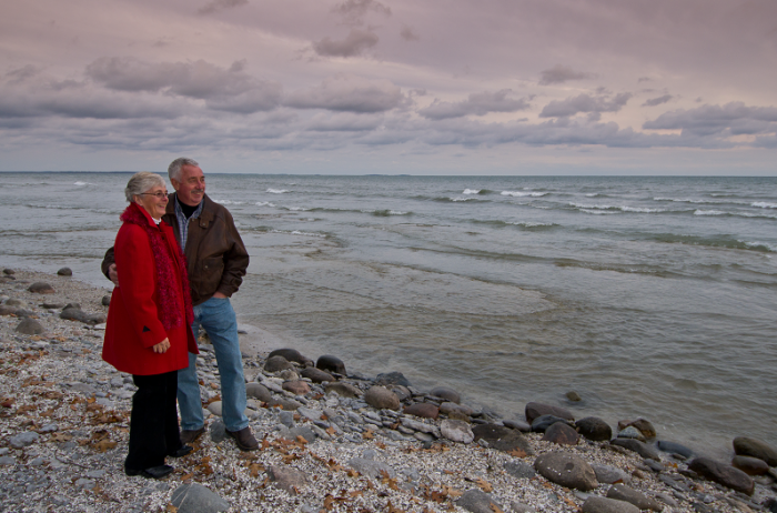 couple standing on grey shoreline