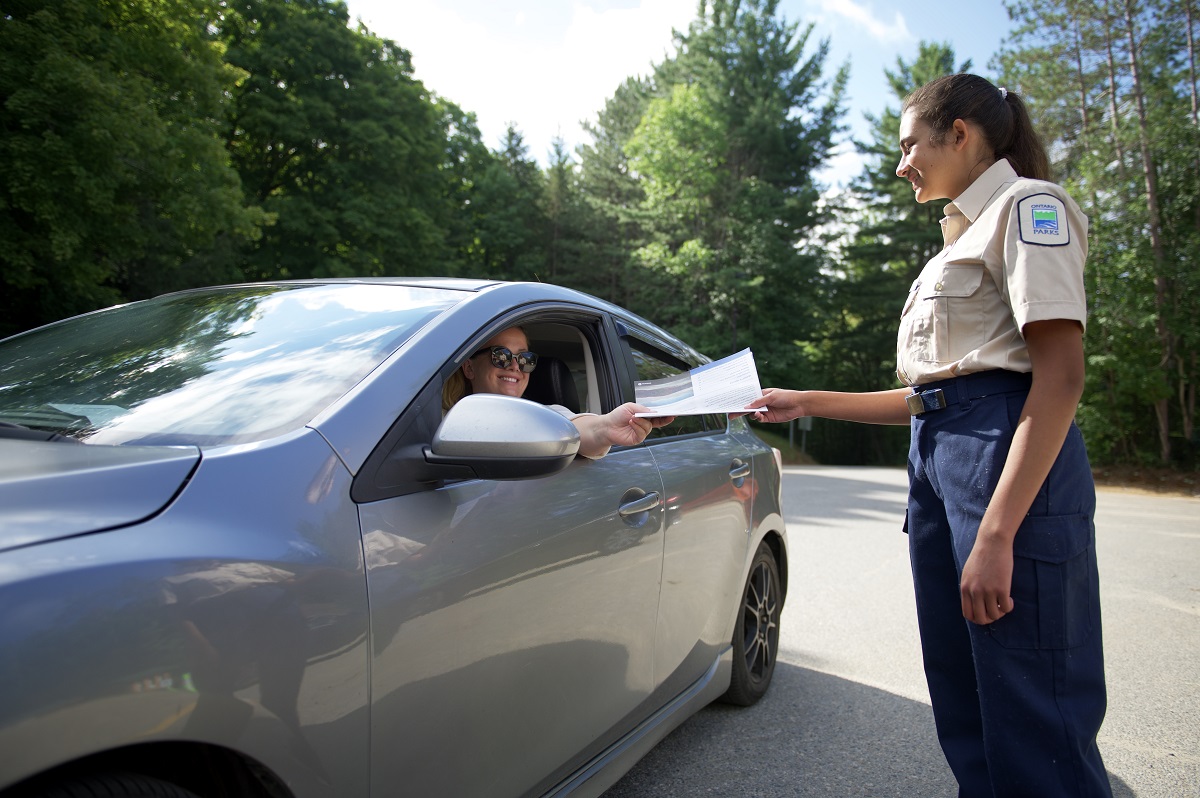 staff greeting car at park gate