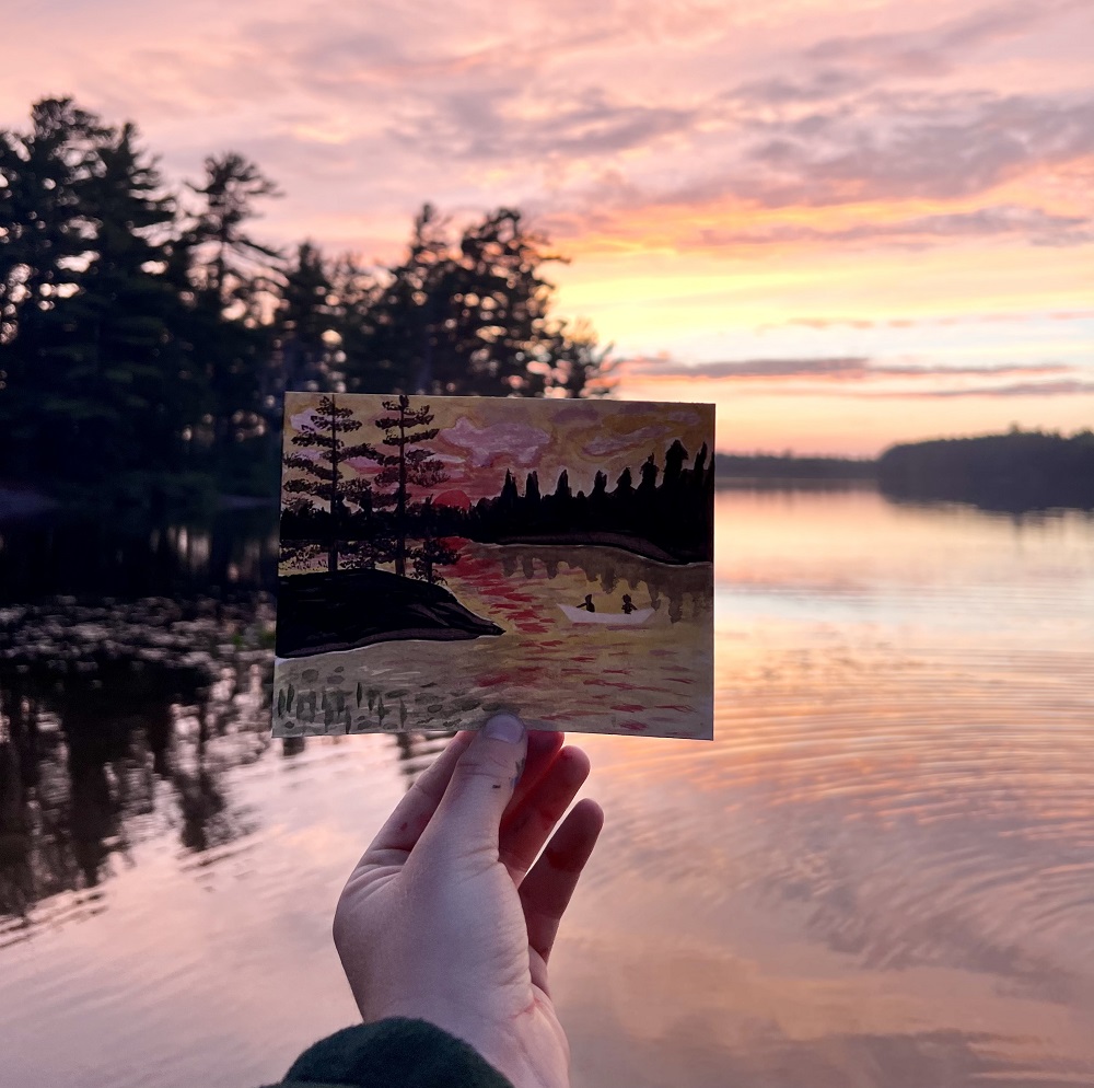 hand holding sunset painting at sunset