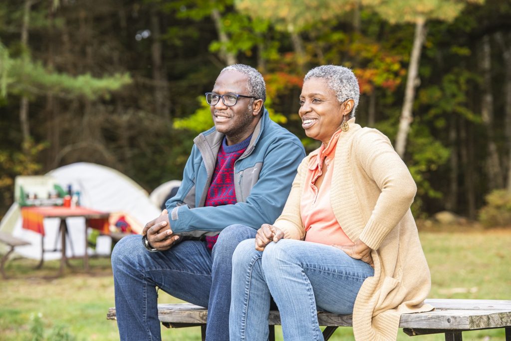 couple sitting on picnic table looking at fall colours