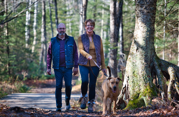 Two adults walking with their dog