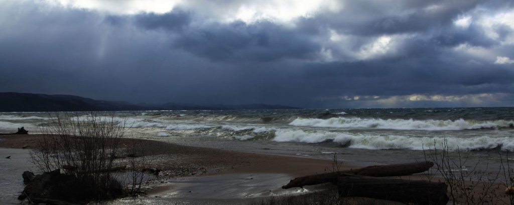Storm clouds over lake with crashing waves