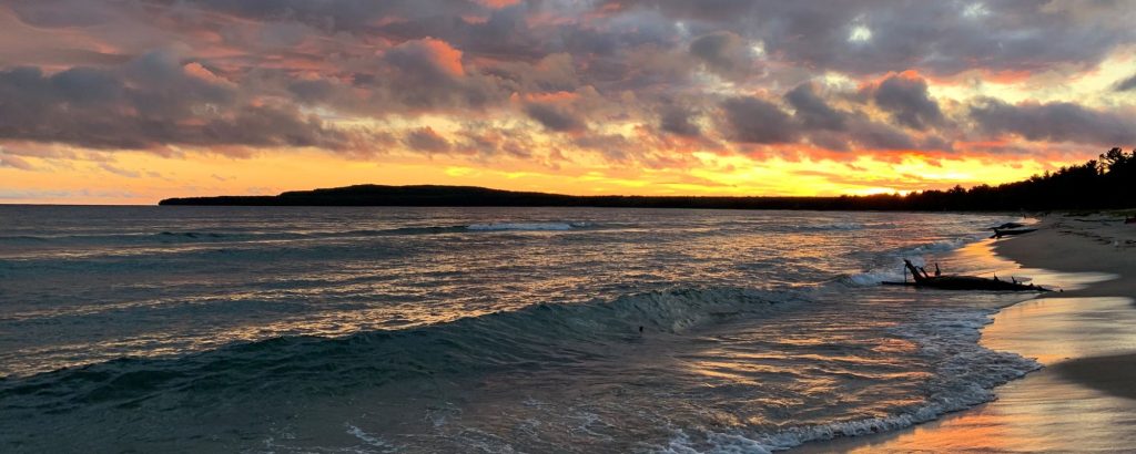 sunset over beach with crashing waves